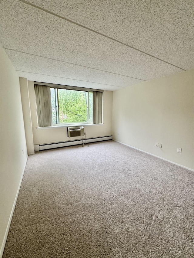 carpeted spare room featuring baseboard heating and baseboards