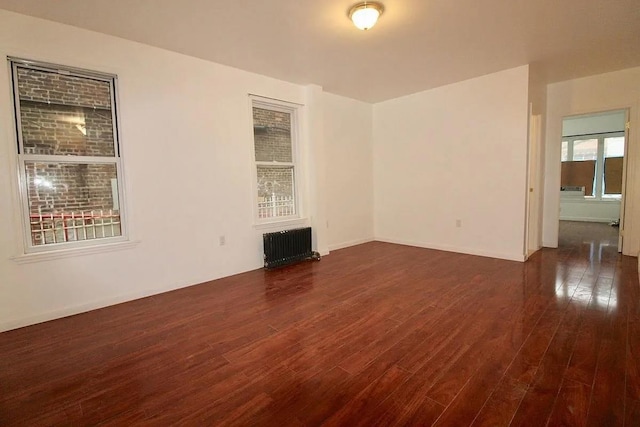 empty room featuring radiator and wood finished floors