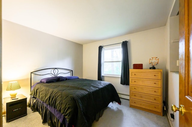 bedroom featuring a baseboard heating unit and light colored carpet
