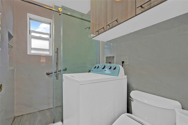 full bathroom with washer / dryer, a stall shower, tile walls, and toilet