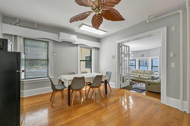 541 Broadway, Monticello, NY 12701 - dining area with a wall unit AC, light wood-type flooring, baseboards, and plenty of natural light