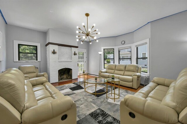 541 Broadway, Monticello, NY 12701 - living area with a chandelier, a brick fireplace, radiator heating unit, and wood finished floors