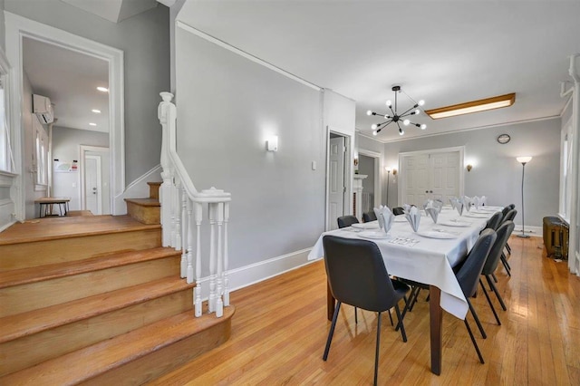 541 Broadway, Monticello, NY 12701 - dining area featuring a chandelier, stairs, light wood-style flooring, baseboards, and a wall mounted AC