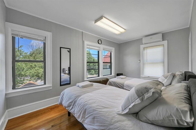 541 Broadway, Monticello, NY 12701 - bedroom featuring a wall mounted AC, crown molding, wood finished floors, and baseboards