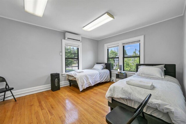 541 Broadway, Monticello, NY 12701 - bedroom featuring a wall unit AC, light wood-style flooring, crown molding, and baseboards