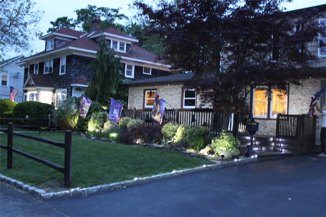 2 Burnett Ave, Bay Shore, NY 11706 - view of front facade featuring stone siding, a chimney, and a deck
