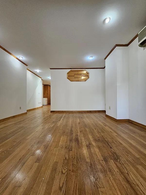 basement featuring crown molding, baseboards, wood finished floors, and recessed lighting