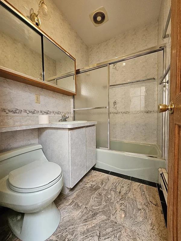 full bath featuring toilet, vanity, and  shower combination