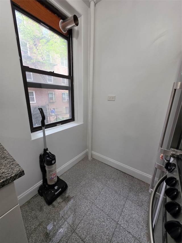 unfurnished room with baseboards