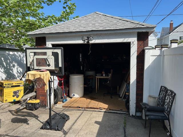 view of outbuilding with fence and a garage