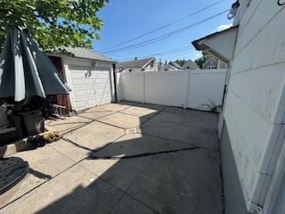 62-53 80th Rd, Glendale, NY 11385 - fenced backyard with a patio, a detached garage, and an outbuilding