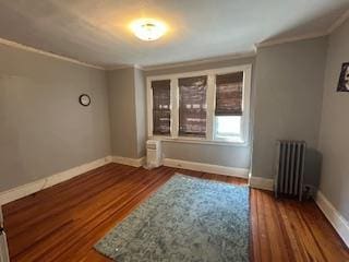 62-53 80th Rd, Glendale, NY 11385 - spare room featuring radiator heating unit, ornamental molding, and wood finished floors