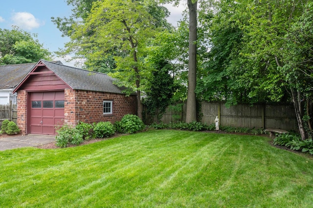 view of yard featuring driveway and a garage