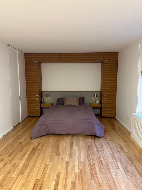 bedroom with light wood-type flooring and baseboards