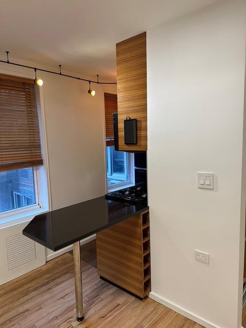 kitchen with light wood-style floors, baseboards, and track lighting