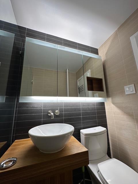 2665 Homecrest Ave Unit 1W, Brooklyn, NY 11235 - bathroom featuring tile walls, toilet, and vanity