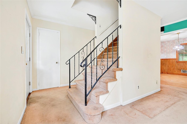 staircase with carpet floors, wood walls, and baseboards
