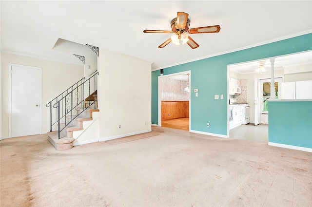 unfurnished living room featuring a ceiling fan, crown molding, stairway, and baseboards