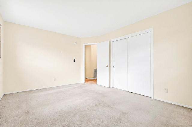 unfurnished bedroom with carpet, a closet, and baseboards