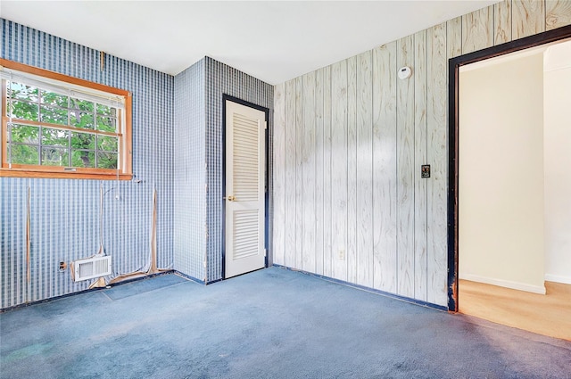 carpeted spare room featuring wallpapered walls and baseboards
