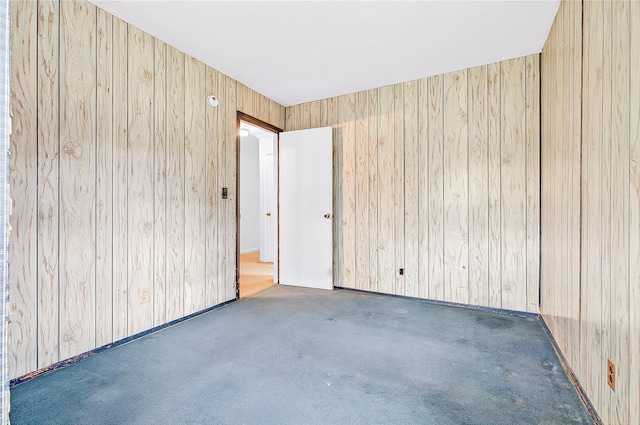 carpeted empty room with wooden walls