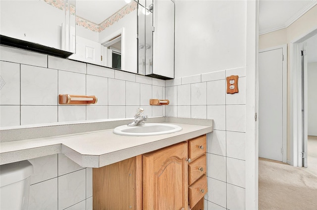 bathroom featuring tile walls, vanity, crown molding, and backsplash