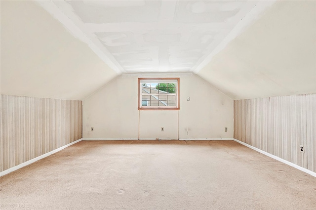 bonus room featuring vaulted ceiling, light colored carpet, and baseboards