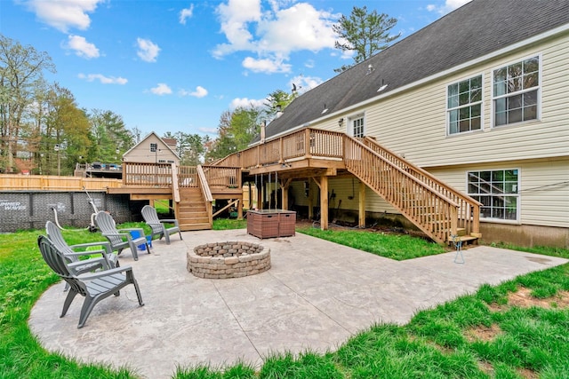 view of patio / terrace with stairs, a fire pit, a deck, and fence