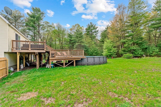 view of green lawn with a wooden deck and a swimming pool
