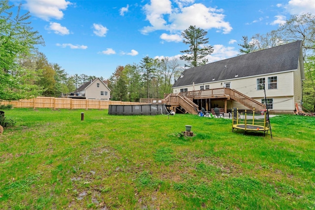 rear view of house with stairway, a wooden deck, and an outdoor pool