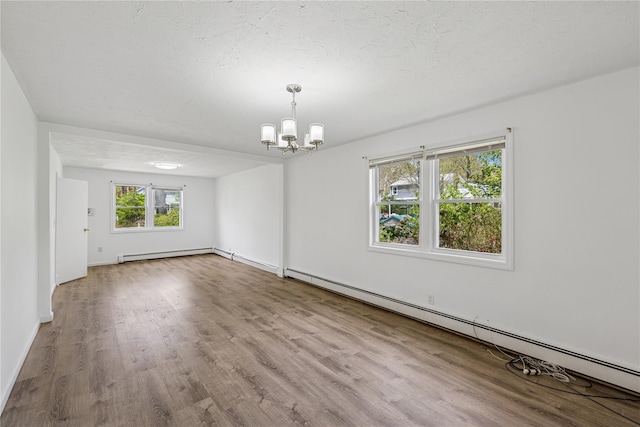 54 Oakdale Ave, Selden, NY 11784 - empty room featuring a chandelier, wood finished floors, baseboard heating, and baseboards