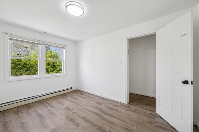 54 Oakdale Ave, Selden, NY 11784 - unfurnished bedroom with a baseboard radiator, wood finished floors, and baseboards