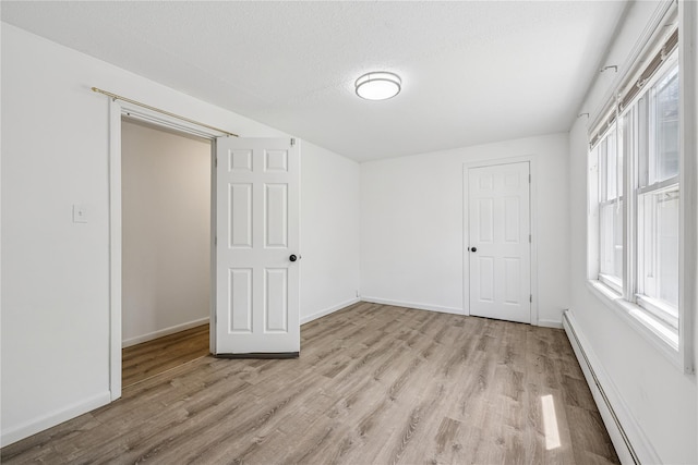54 Oakdale Ave, Selden, NY 11784 - unfurnished bedroom with a baseboard radiator, light wood finished floors, and baseboards