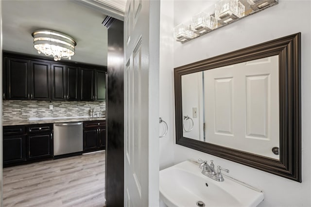 54 Oakdale Ave, Selden, NY 11784 - bathroom featuring a sink, wood finished floors, backsplash, and a chandelier