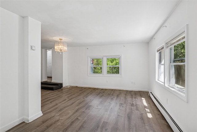54 Oakdale Ave, Selden, NY 11784 - unfurnished living room featuring baseboard heating, a chandelier, wood finished floors, and baseboards
