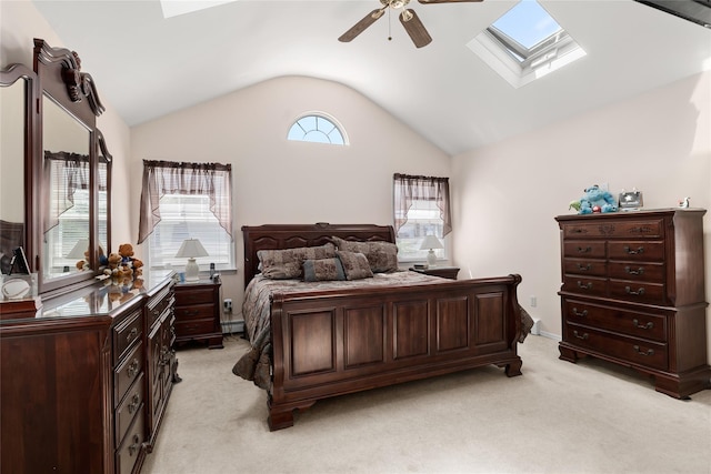 bedroom with a skylight, vaulted ceiling, light colored carpet, a baseboard radiator, and a ceiling fan