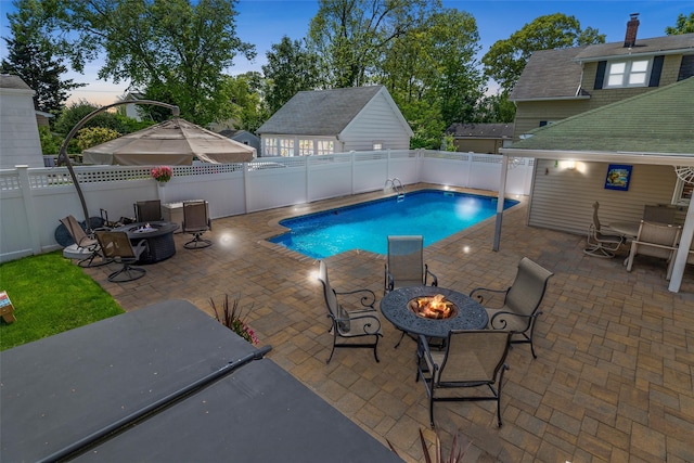 view of swimming pool with an outdoor fire pit, a patio, and a fenced backyard