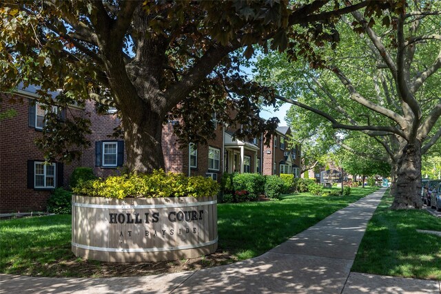 community sign featuring a residential view and a yard