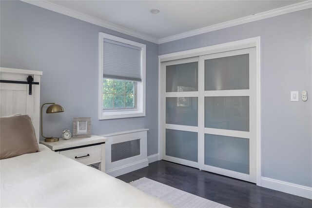 bedroom with baseboards, crown molding, dark wood-style flooring, and a barn door