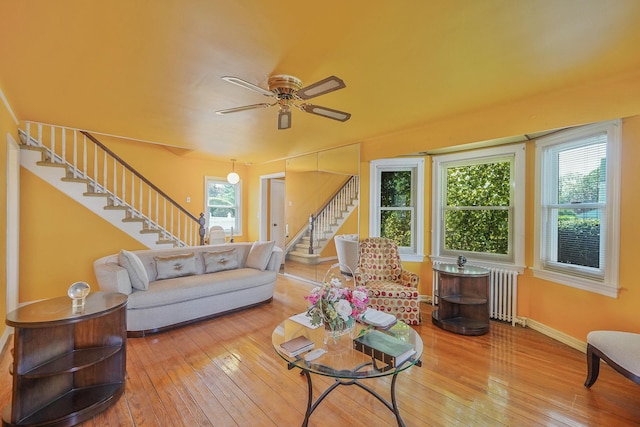 66 Elmwood Ave, Hempstead, NY 11550 - living room with stairs, hardwood / wood-style floors, a ceiling fan, radiator, and baseboards