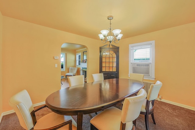 66 Elmwood Ave, Hempstead, NY 11550 - carpeted dining room featuring arched walkways, a chandelier, baseboards, and cooling unit