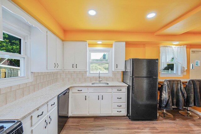 66 Elmwood Ave, Hempstead, NY 11550 - kitchen with freestanding refrigerator, a sink, dishwasher, wood finished floors, and white cabinets