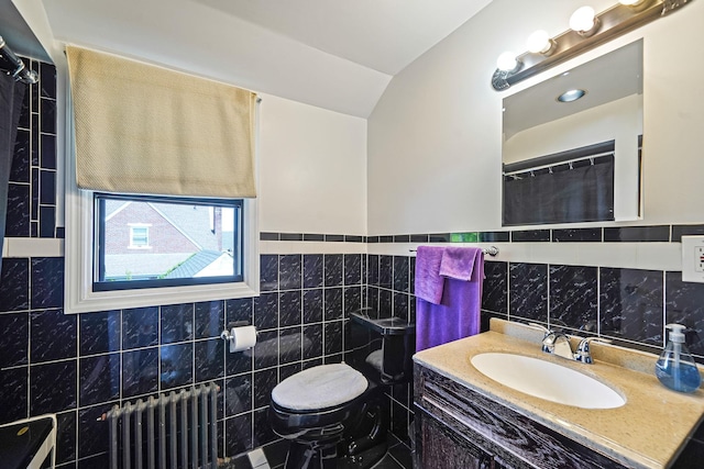 66 Elmwood Ave, Hempstead, NY 11550 - bathroom with radiator heating unit, tile walls, toilet, vanity, and lofted ceiling