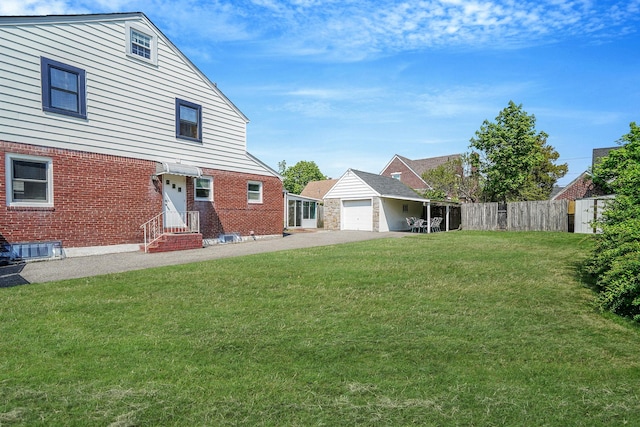 66 Elmwood Ave, Hempstead, NY 11550 - back of house with entry steps, brick siding, driveway, and a garage