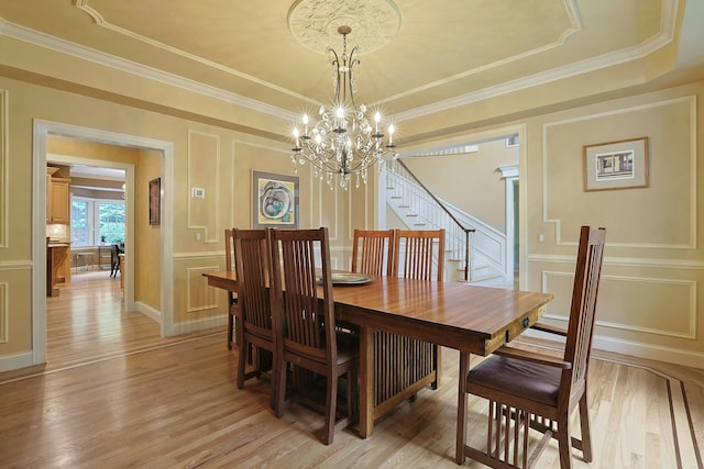 1988 Beekman Ct, Yorktown Heights, NY 10598 - dining space with a decorative wall, light wood-style flooring, a chandelier, stairs, and a tray ceiling