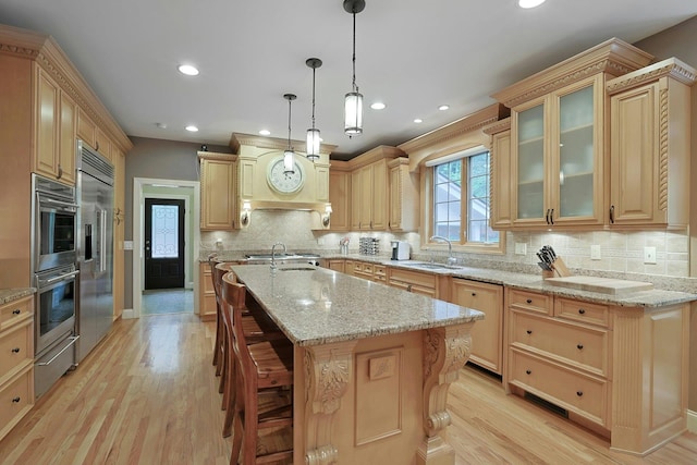 1988 Beekman Ct, Yorktown Heights, NY 10598 - kitchen featuring a sink, a warming drawer, stainless steel appliances, light brown cabinetry, and light wood finished floors
