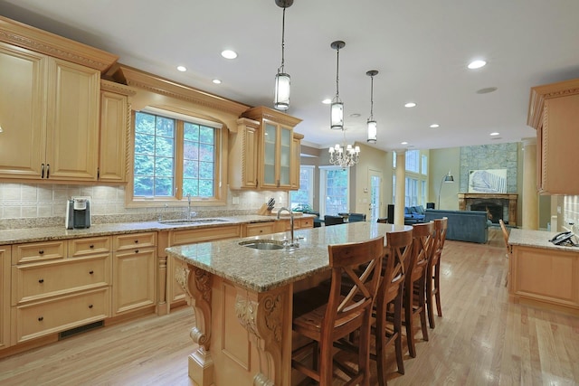 1988 Beekman Ct, Yorktown Heights, NY 10598 - kitchen with a sink, light wood-type flooring, backsplash, a stone fireplace, and recessed lighting
