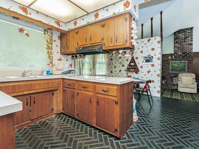 36 Lisa Dr, Dix Hills, NY 11746 - kitchen with under cabinet range hood, a sink, white electric cooktop, light countertops, and wallpapered walls