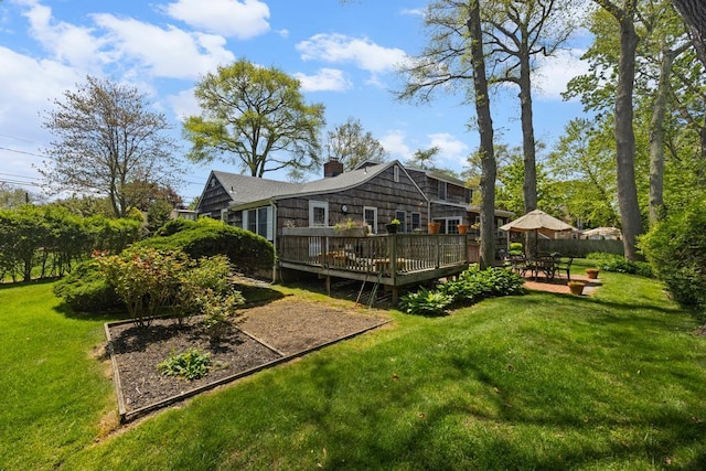 back of house featuring a wooden deck, a chimney, and a yard