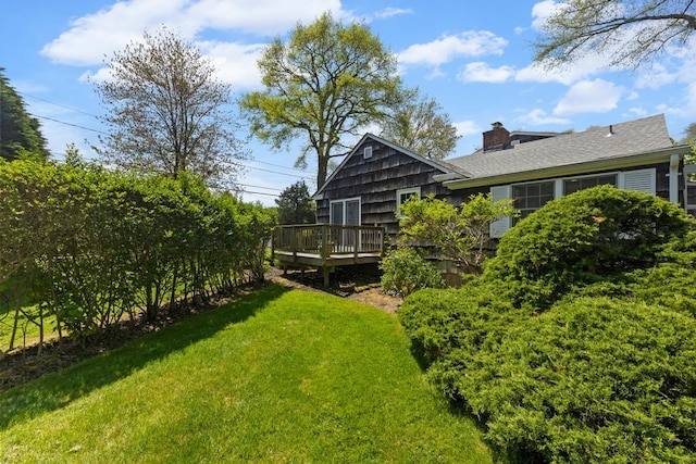 view of green lawn featuring a wooden deck